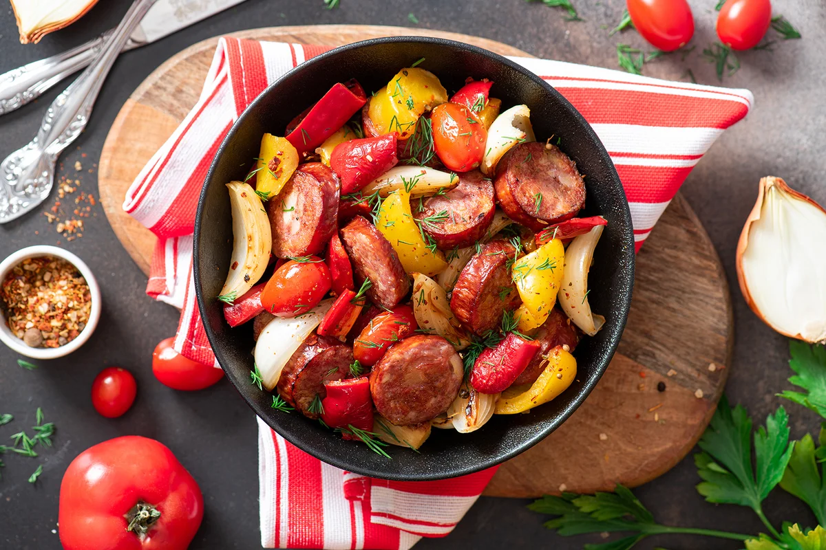 Sausages fried with peppers, tomatoes, and onions