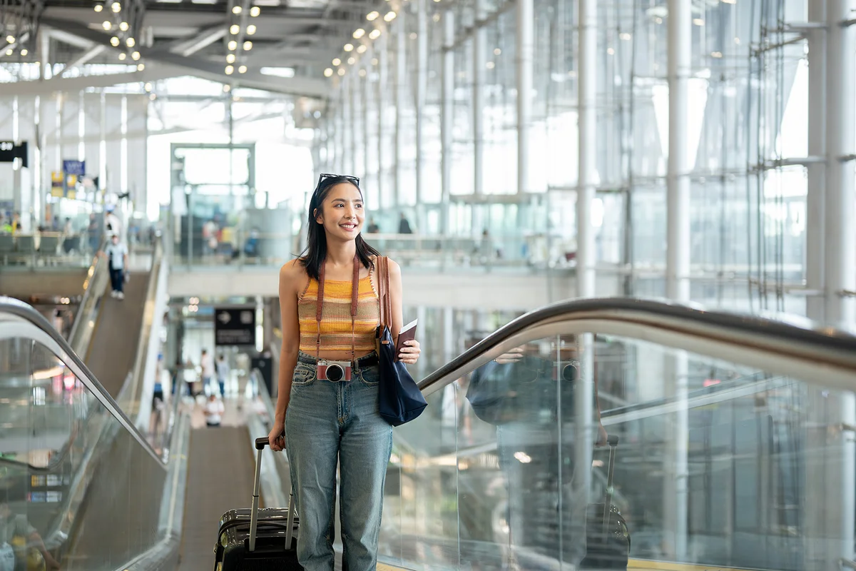 female tourist passenger is on an airport escalator