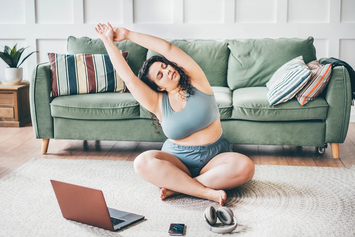 woman in top and shorts turns on online yoga training