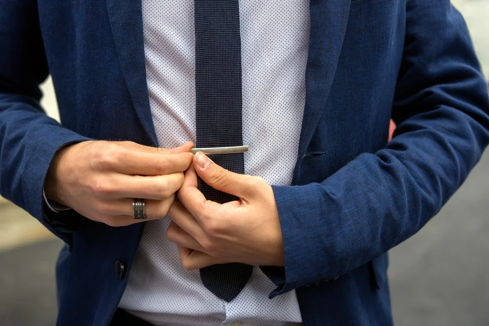 closeup of putting on a tie clip