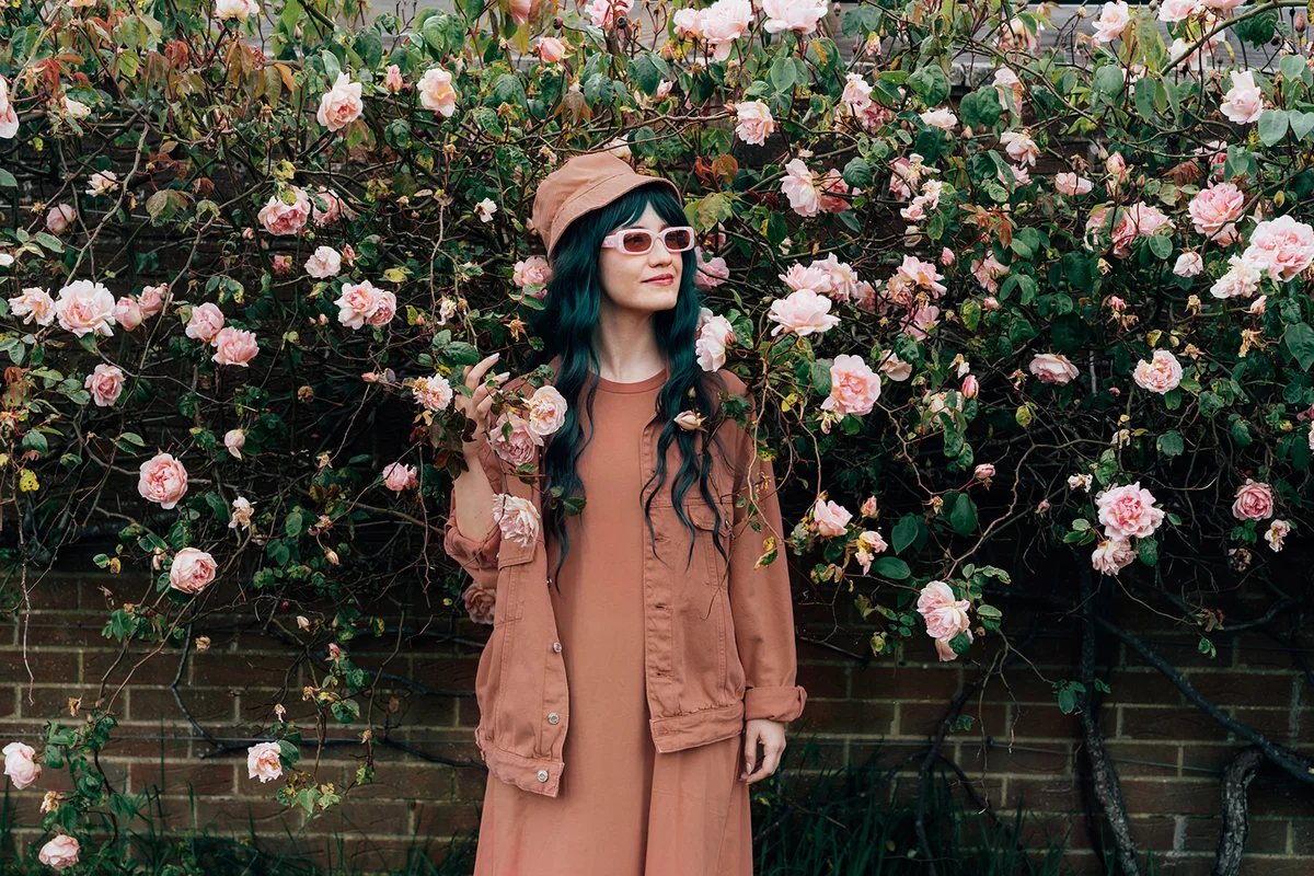 young hipster woman in mocha color dress, jacket, bucket hat and sunglasses