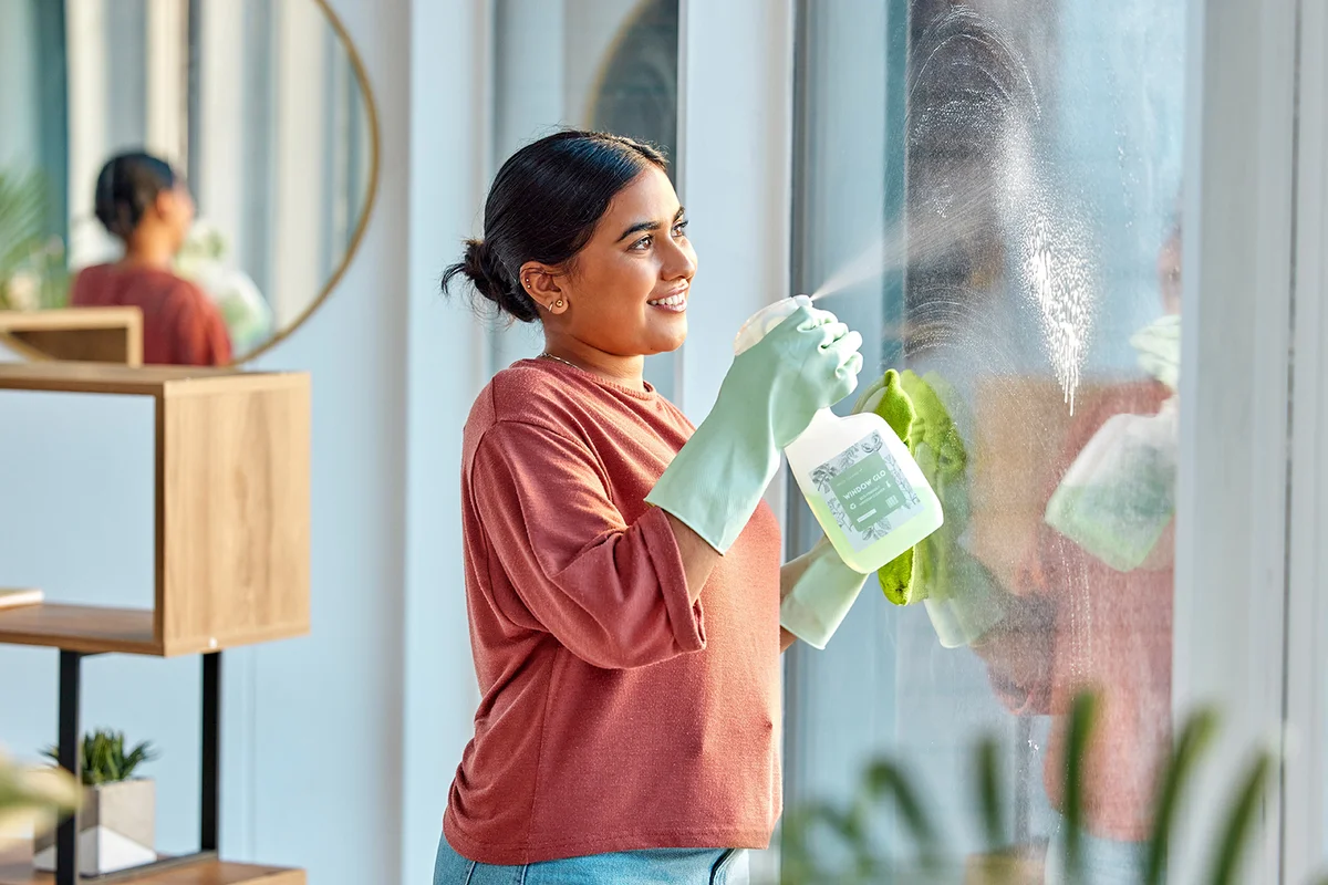 Woman, cleaning and spray product of a cleaner washing a window