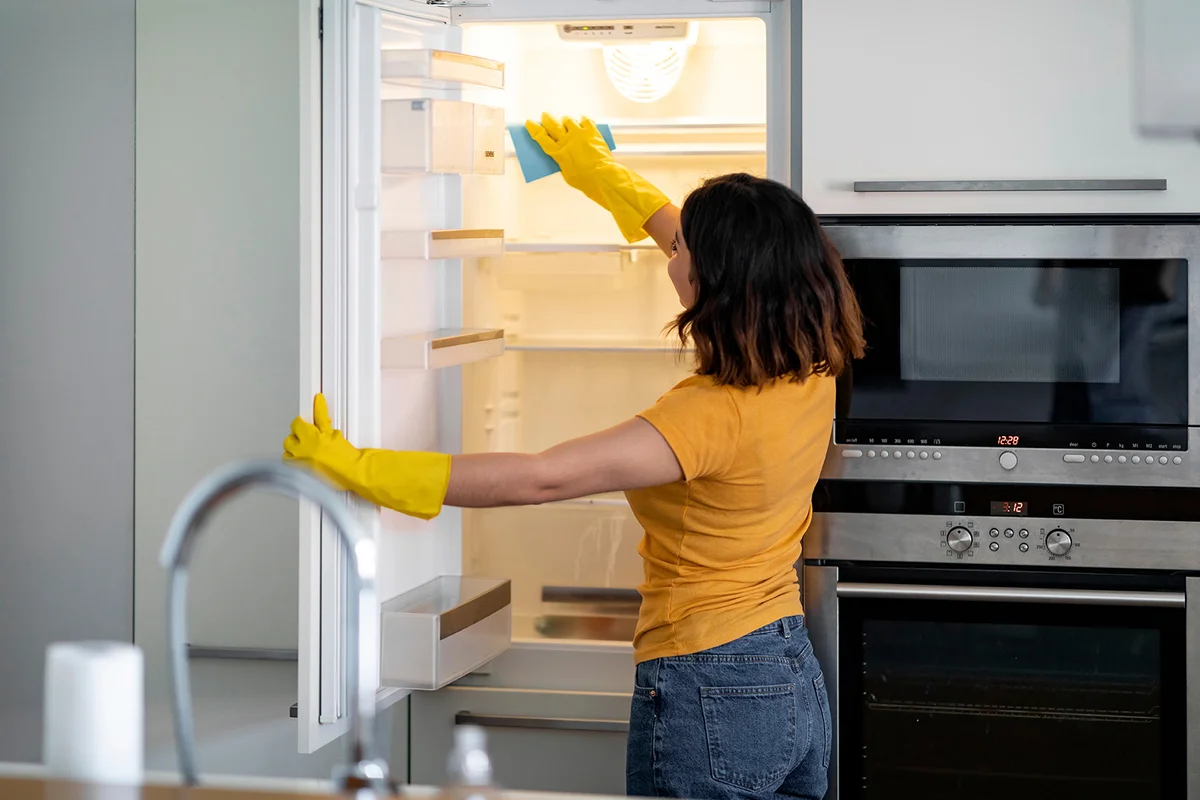 Woman cleaning fridge