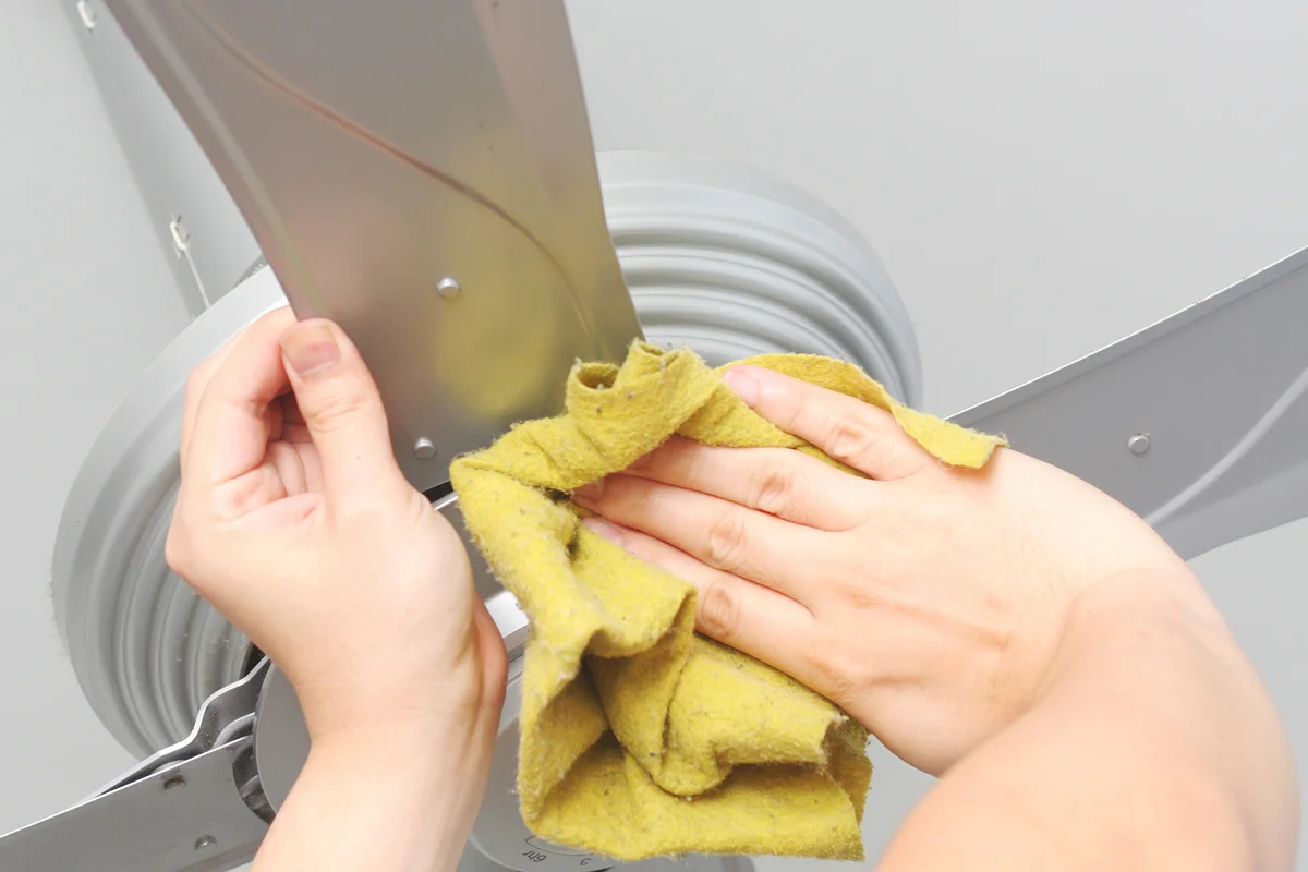 Cleaning the ceiling fan with a cloth