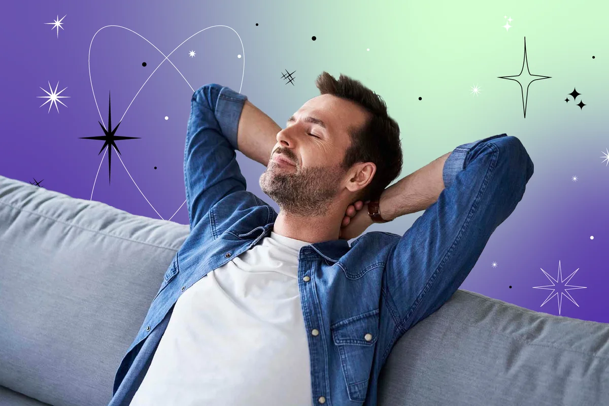 Smiling relaxed man sitting on sofa daydreaming
