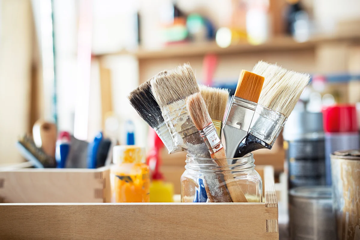 Paint brushes and crafting supplies on the table in a workshop