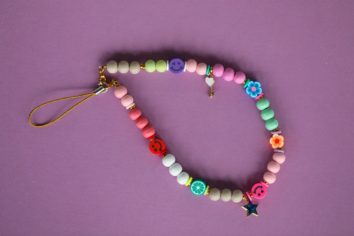 A cute phone charm made with wooden beads and charms.