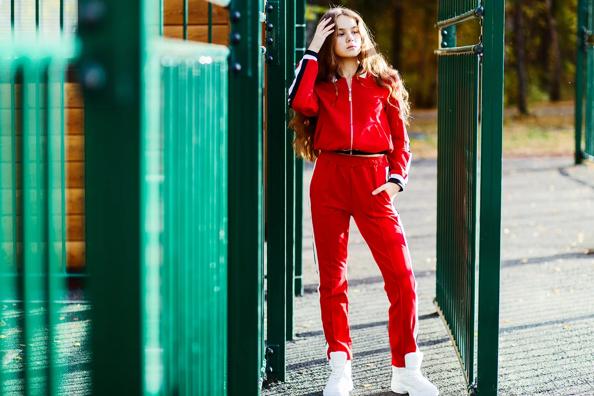 Girl in a red tracksuit with long curly hair