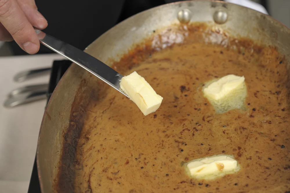 adding butter to pan sauce