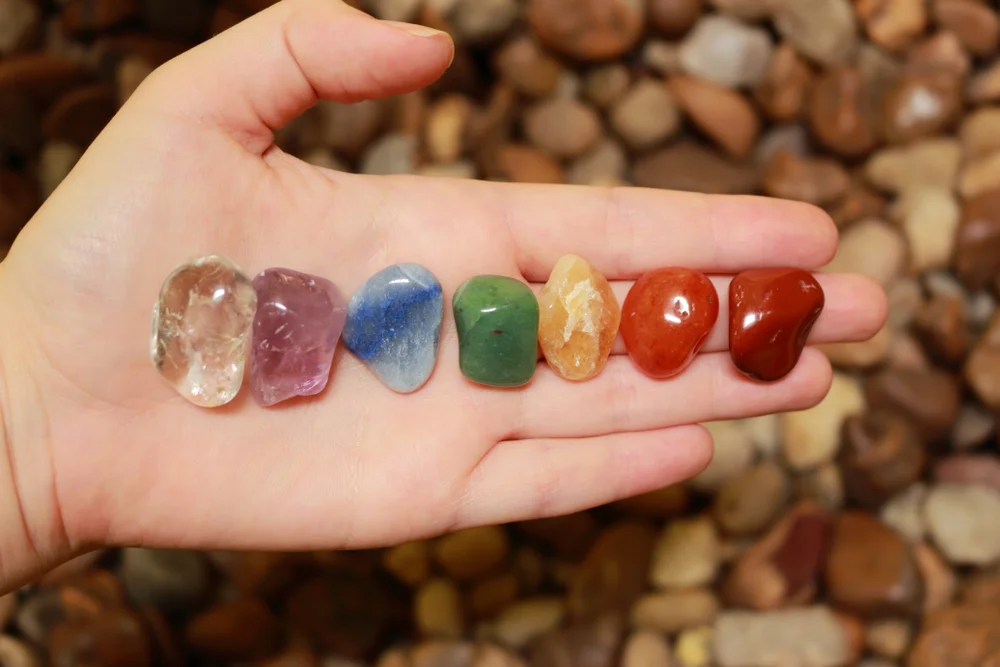 woman's hand holding chakra stones