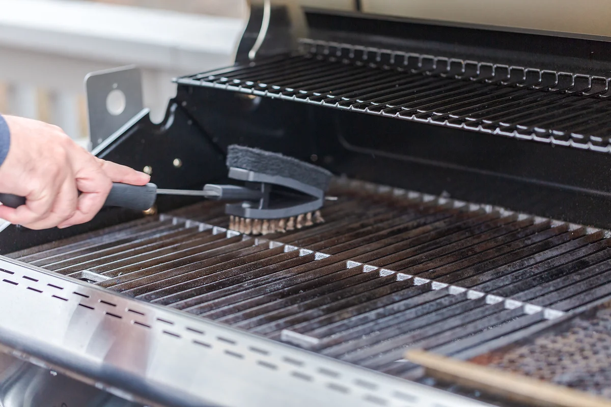 Cleaning outdoor gas grill before next grilling.