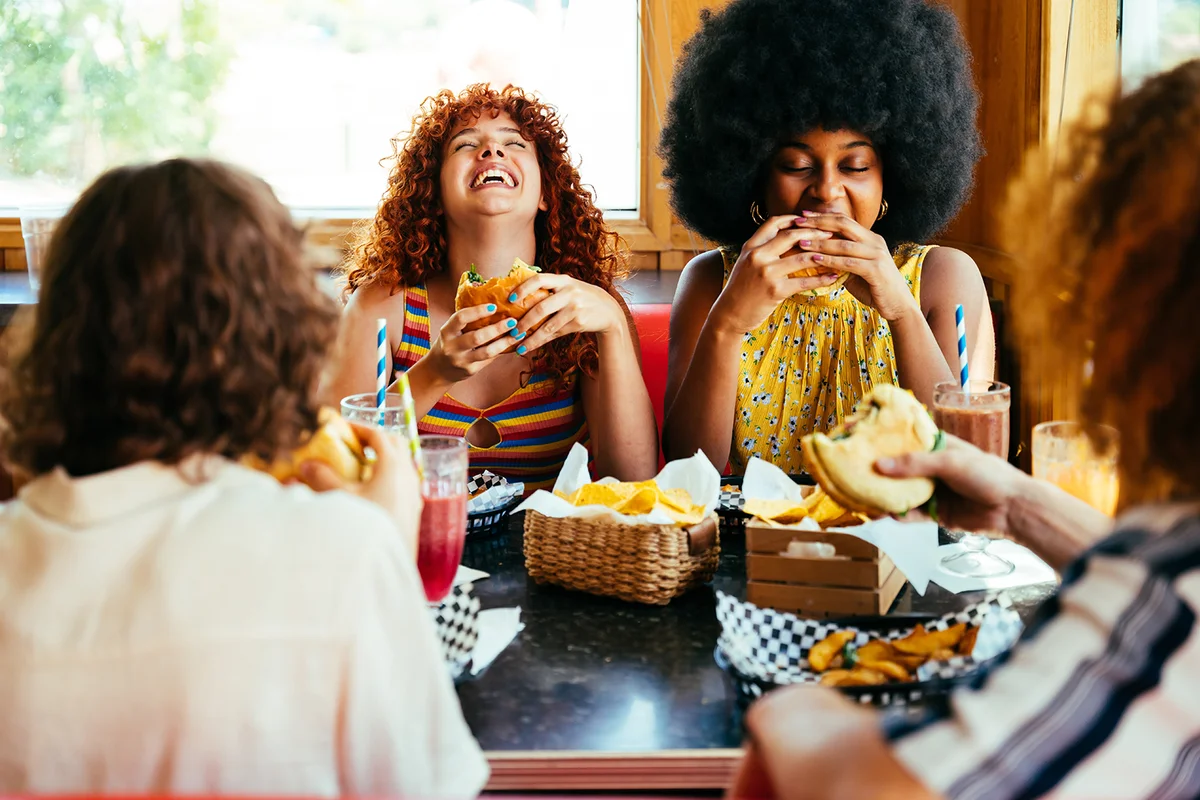 group of friends having meal at 80s vintage diner restaurant