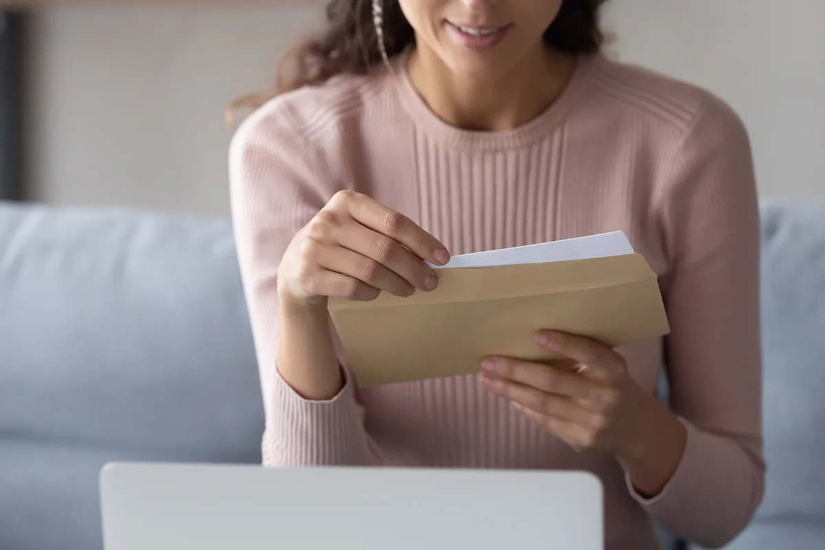 woman hold paper envelope open read postal mail letter at hom