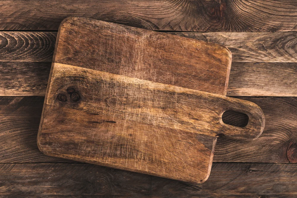old wooden cutting board with knife grooves
