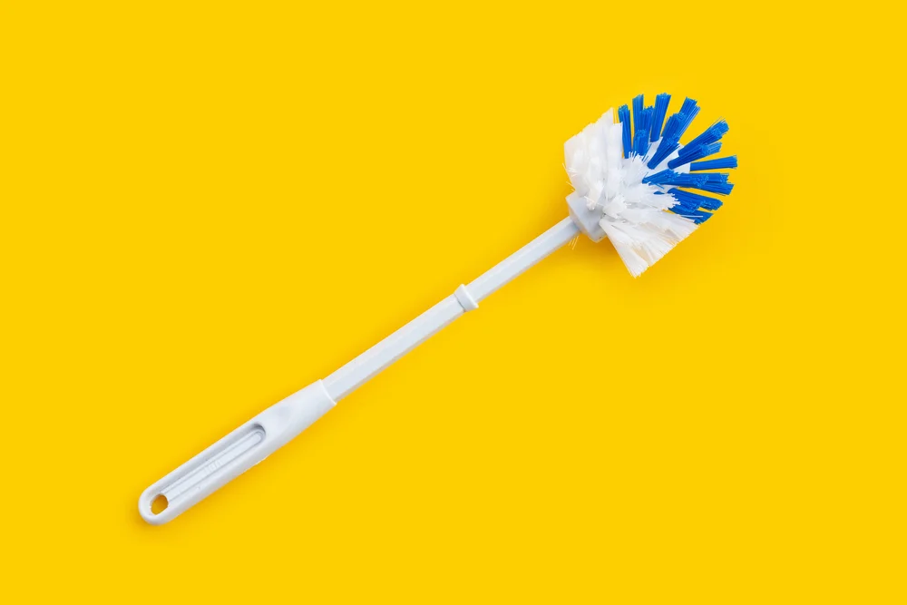 toilet brush on a yellow background