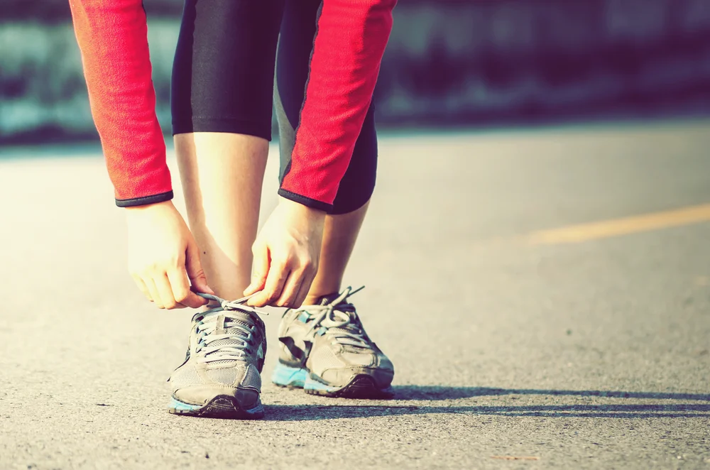 closeup of a woman tying her running shoes