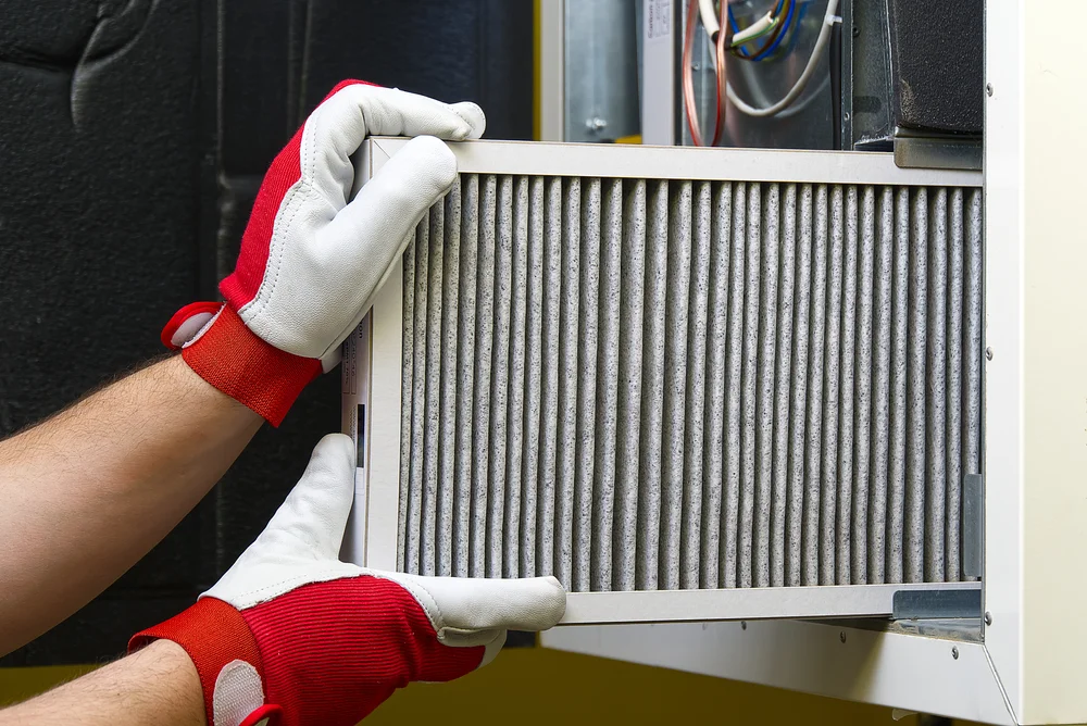 closeup of gloved hands changing an air filter
