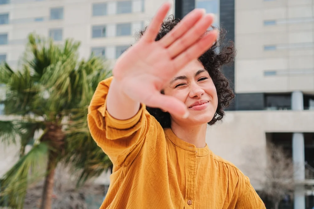 woman holding her hand in front of her face