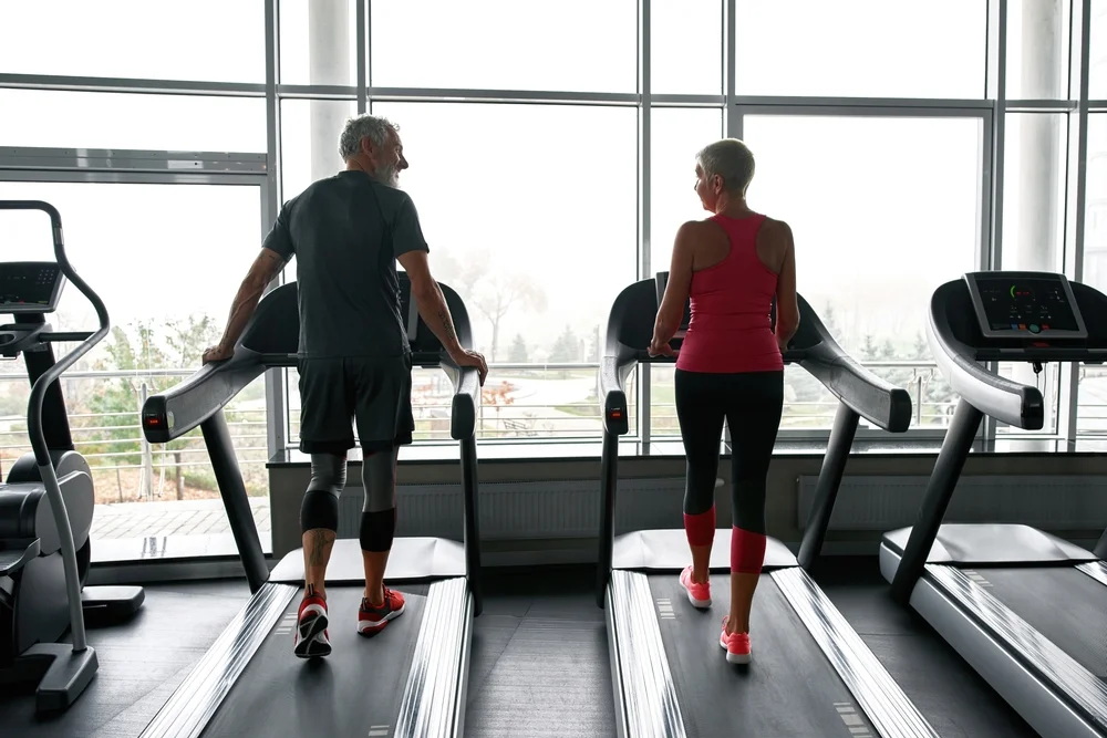 man and woman on treadmills