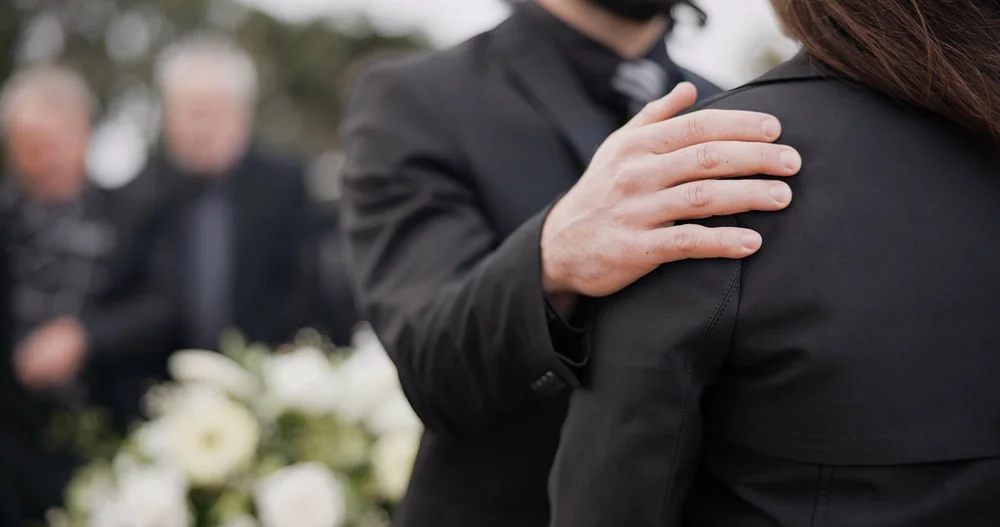 two people talking at a funeral