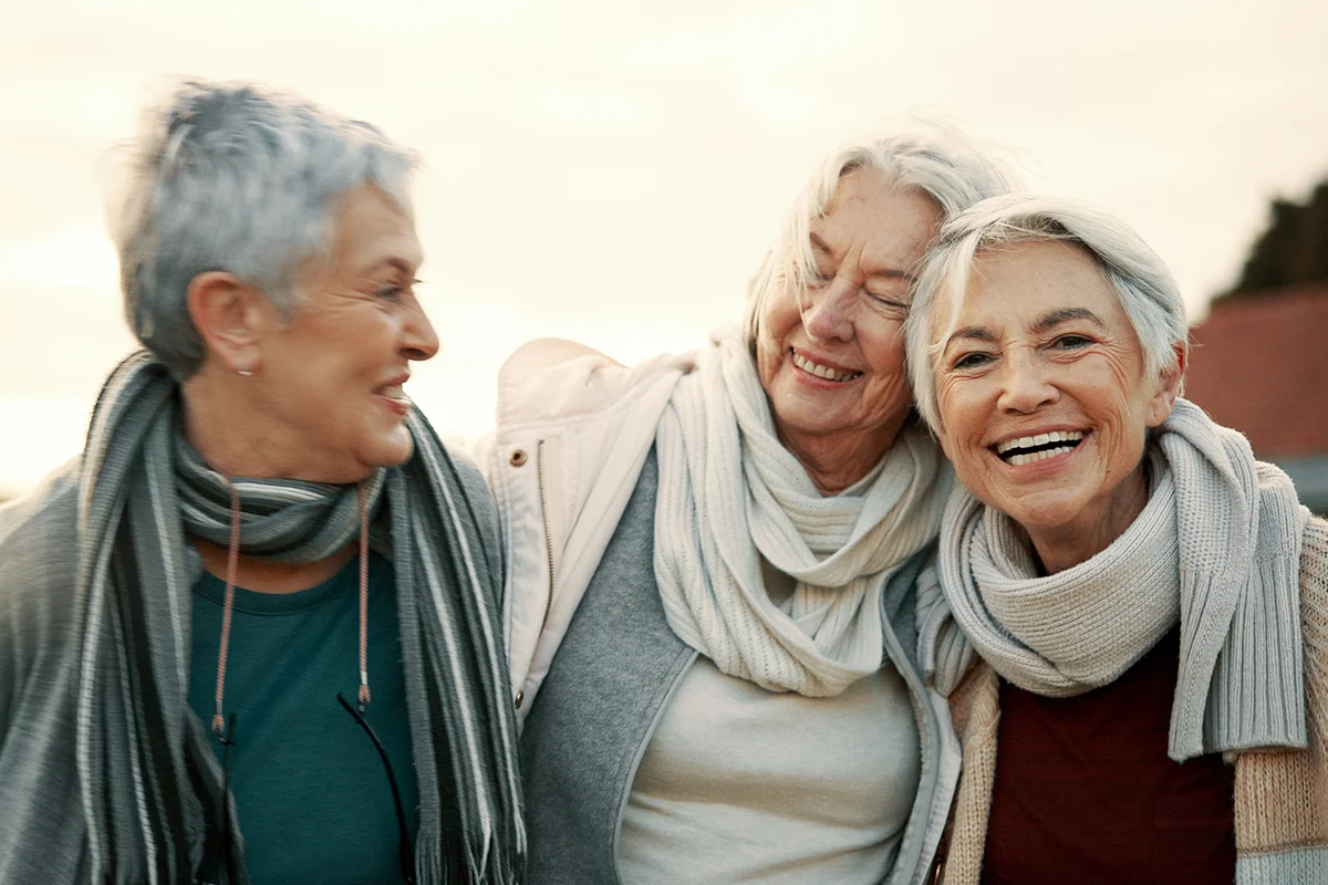 Laughing and senior woman friends outdoor in a park together for bonding during retirement
