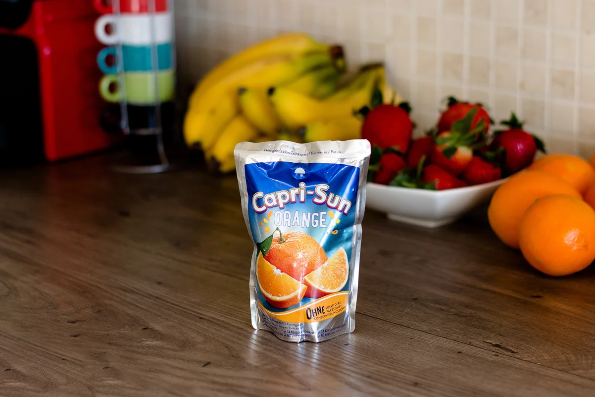 Capri-sun orange juice on top of a wooden table