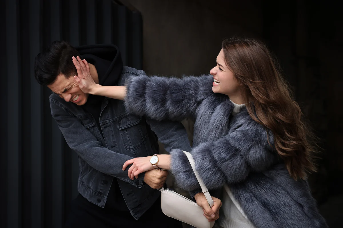 Woman fighting with thief while he trying to steal her bag in alley