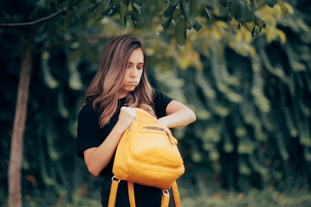 Exasperated woman looking through her purse
