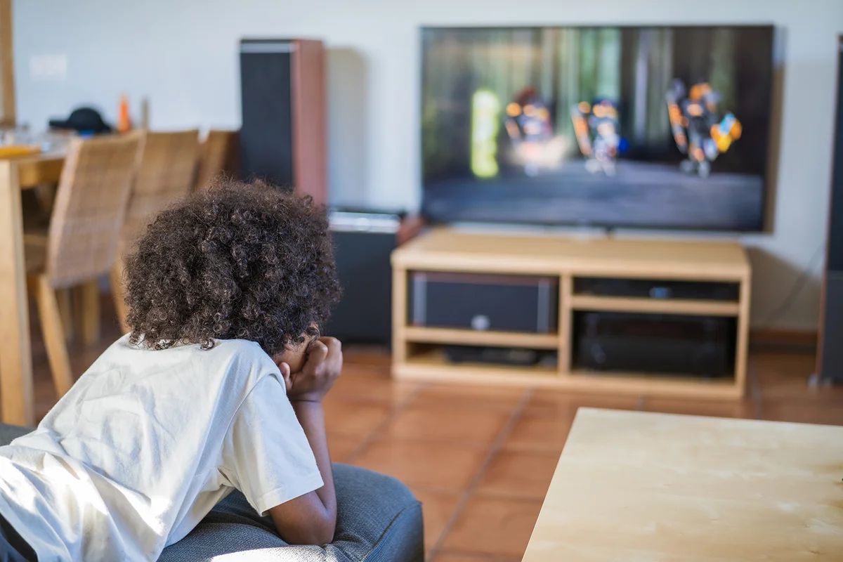 boy watching cartoons on TV at home
