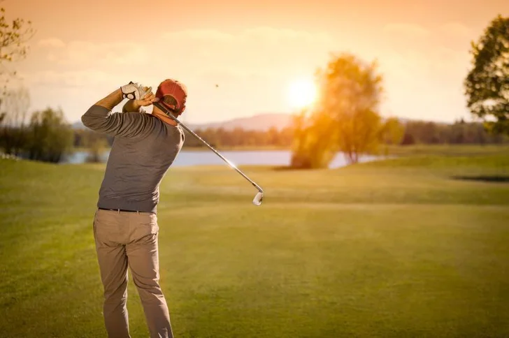 golfer hitting into sunset