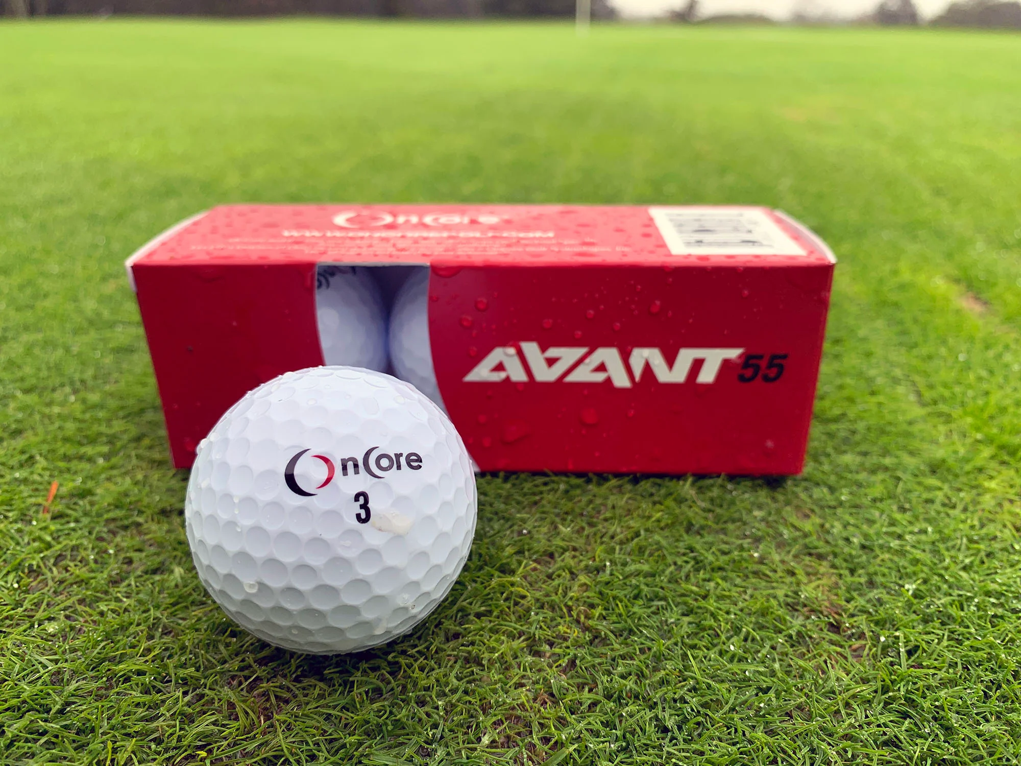 OnCore AVANT 55 golf ball and sleeve on a putting green