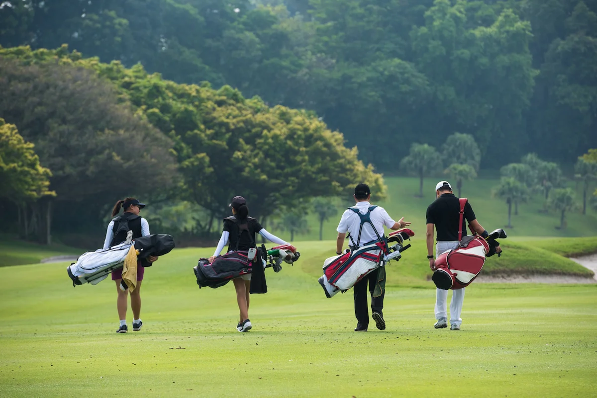 golfers walking with bags on course