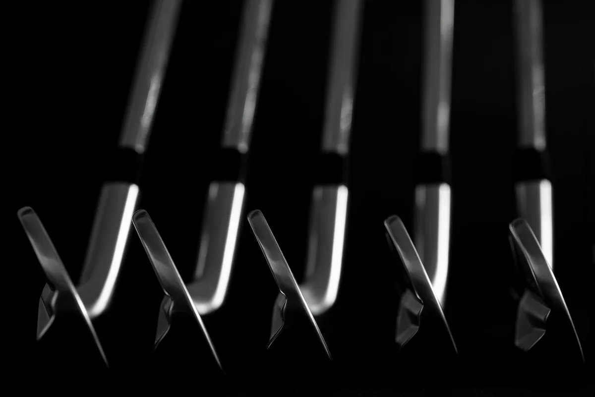Sleek golf clubs with black background