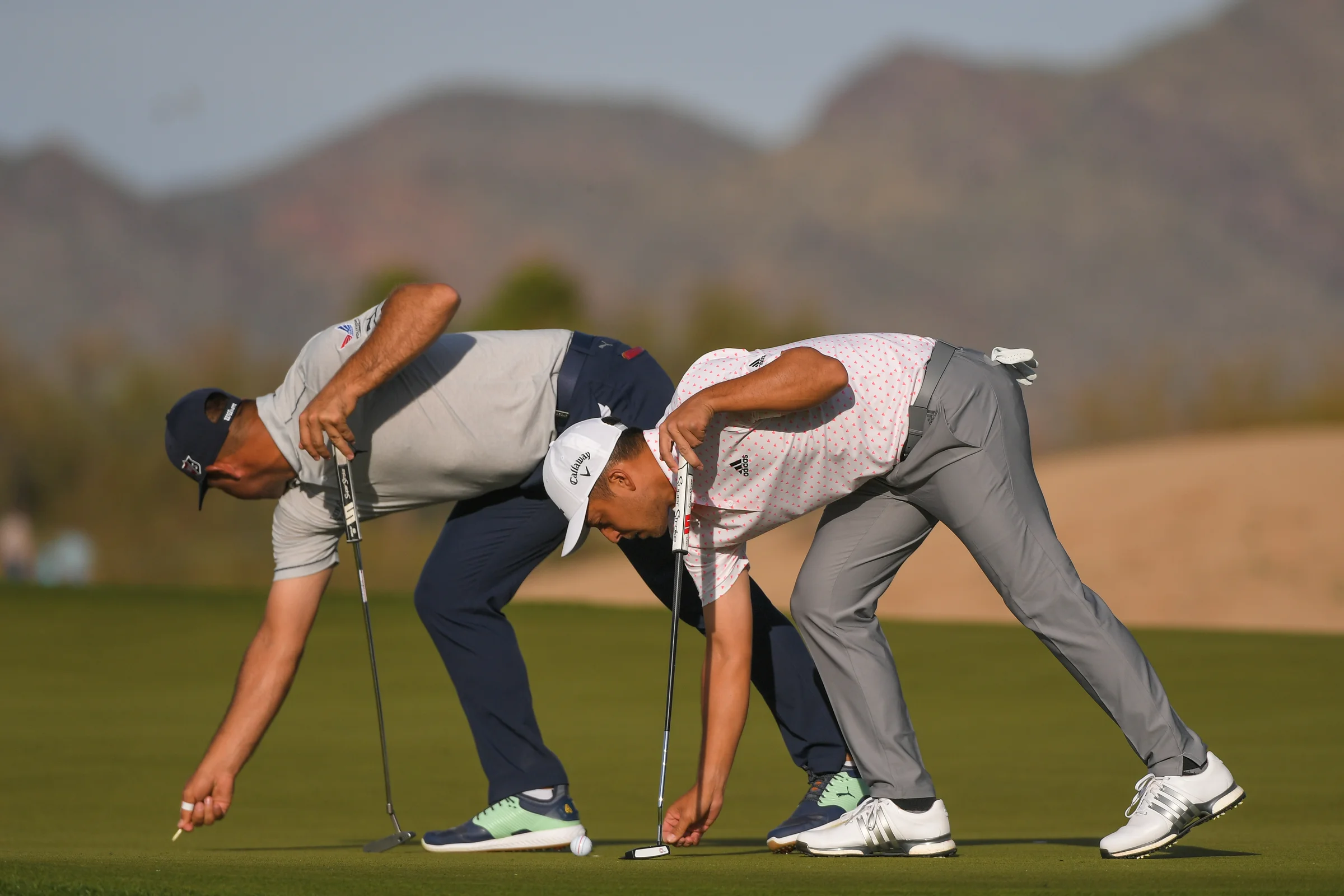 Gary Woodland and Xander Schauffele repair ball marks