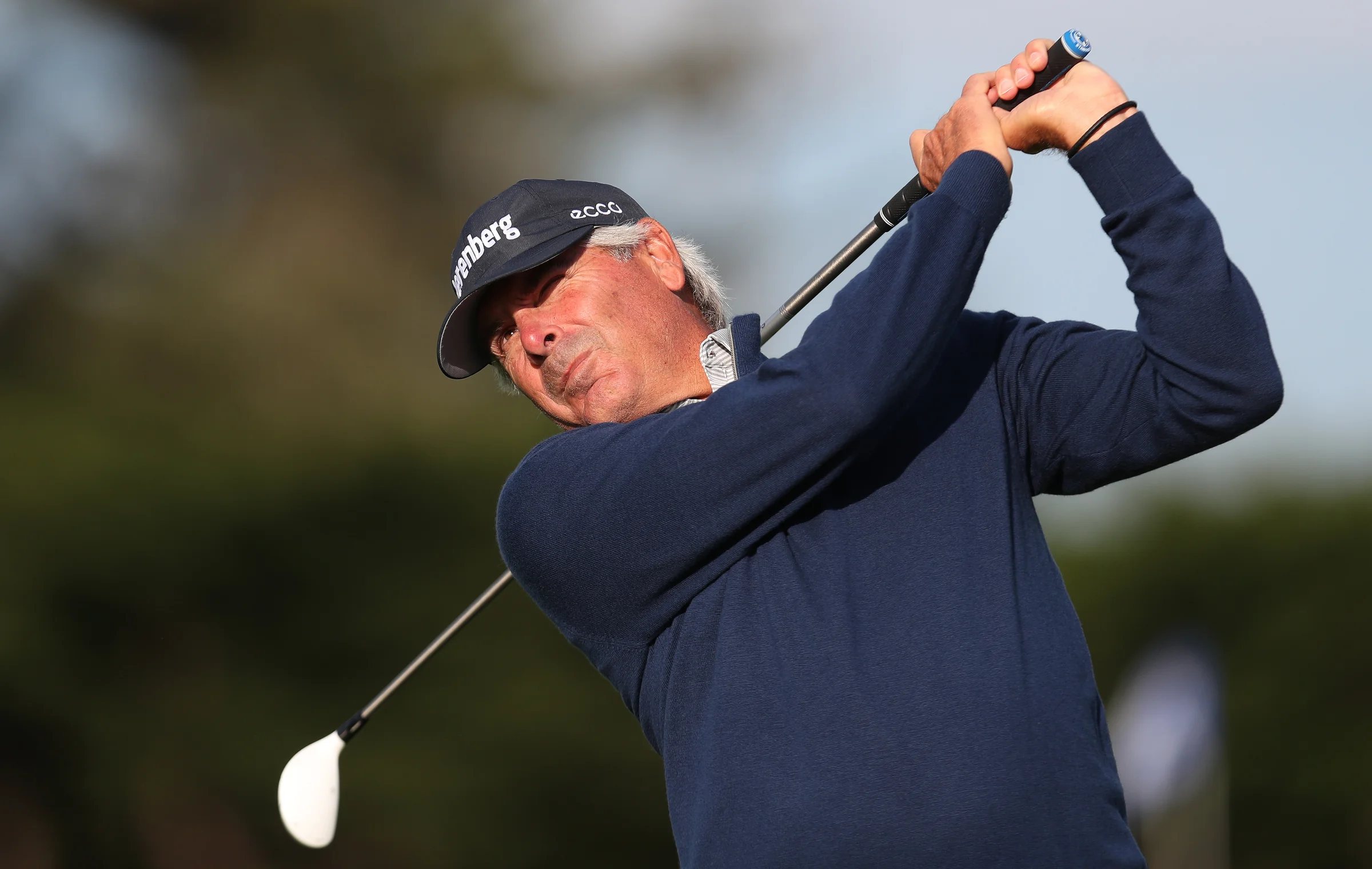 Fred Couples hitting a hybrid golf club