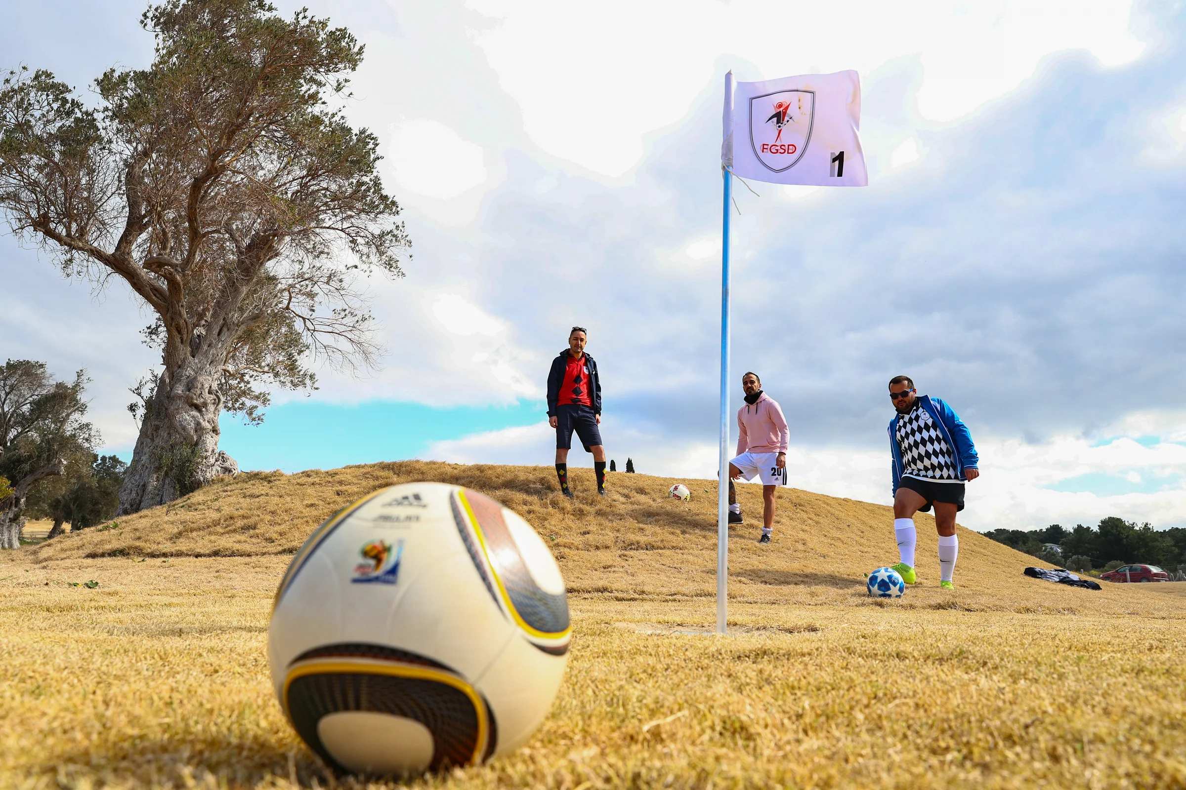 Three men playing footgolf