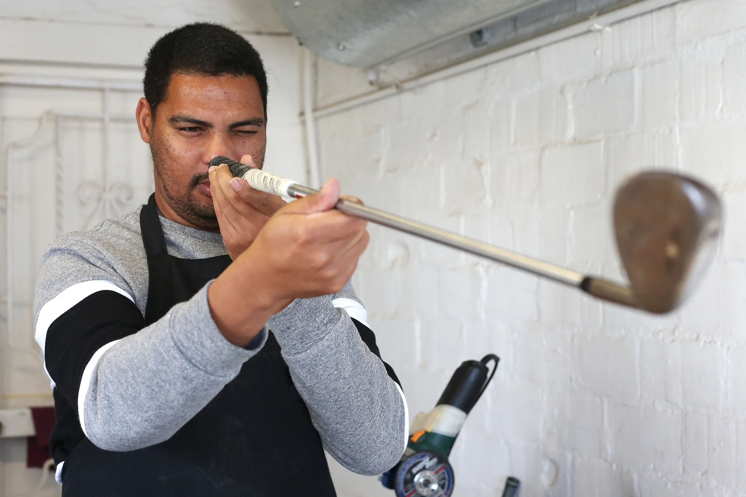 Man inspects golf club closely