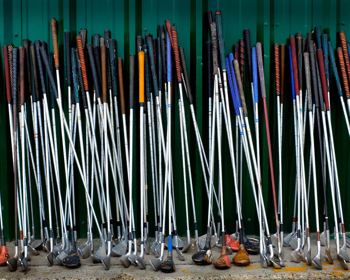 Golf clubs resting on wall