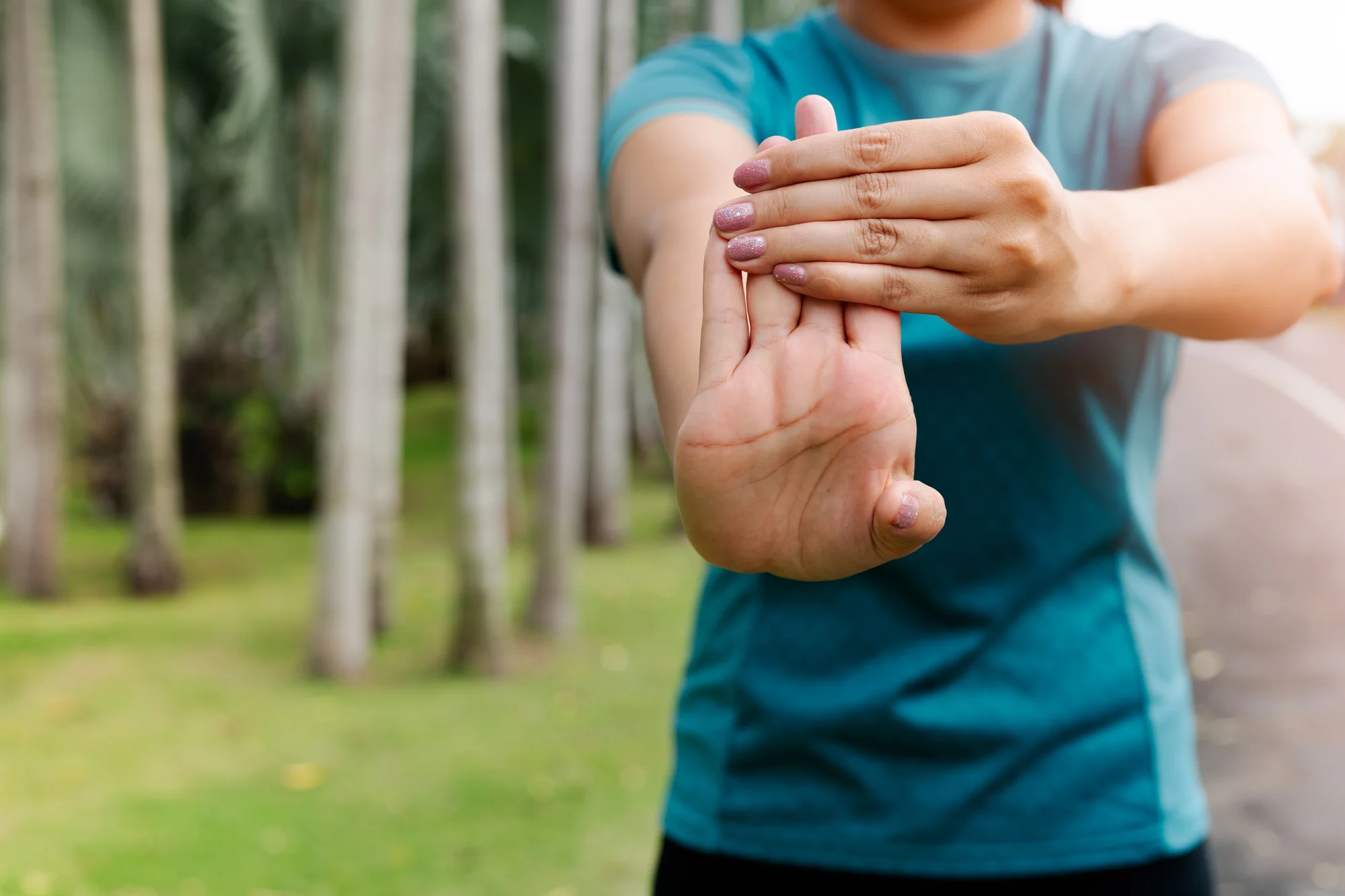 Woman performs wrist flexor exercise