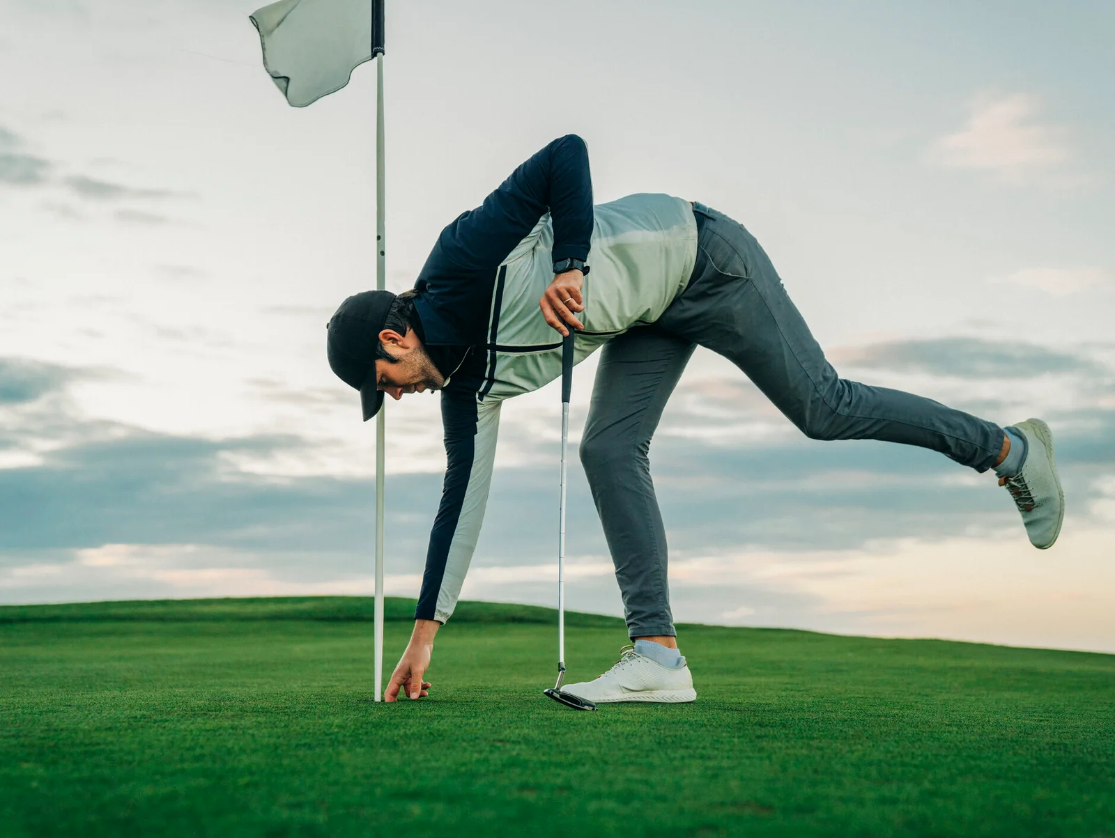 Golfer taking his ball out of the hole after making 10-foot putt