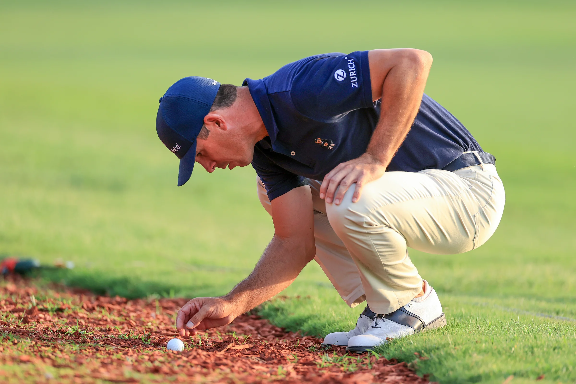 Billy Horschel removes a loose impediment