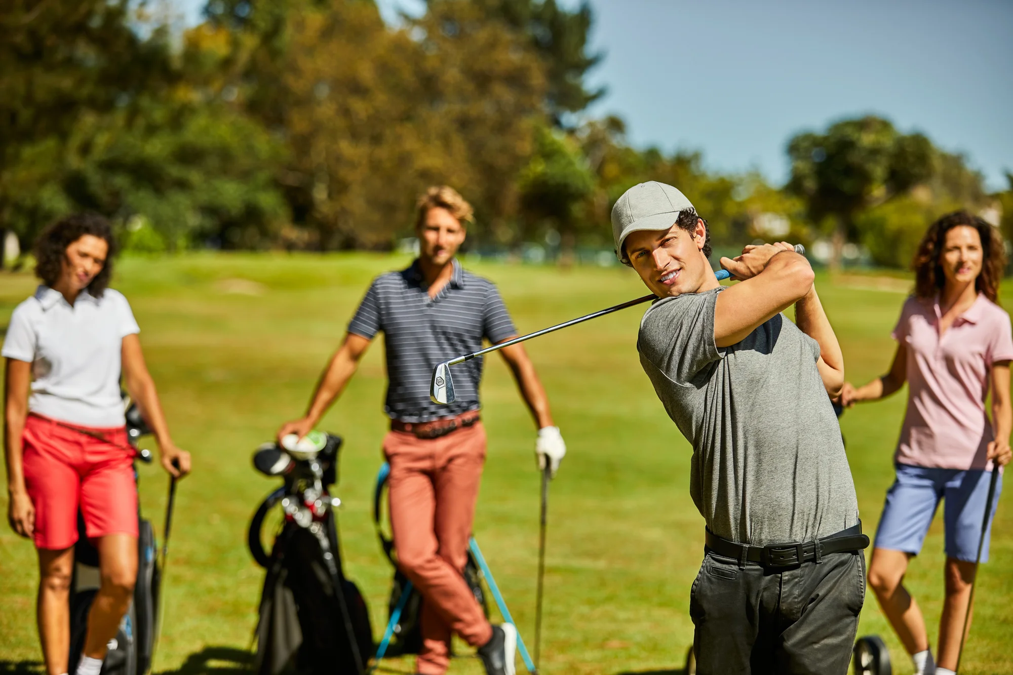Golfer plays while others wait their turn