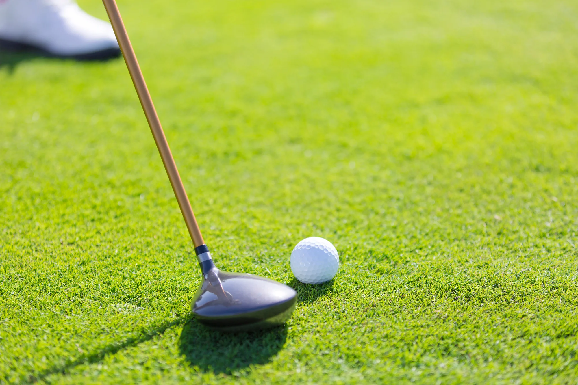 Golfer set up to chip with a 3-wood