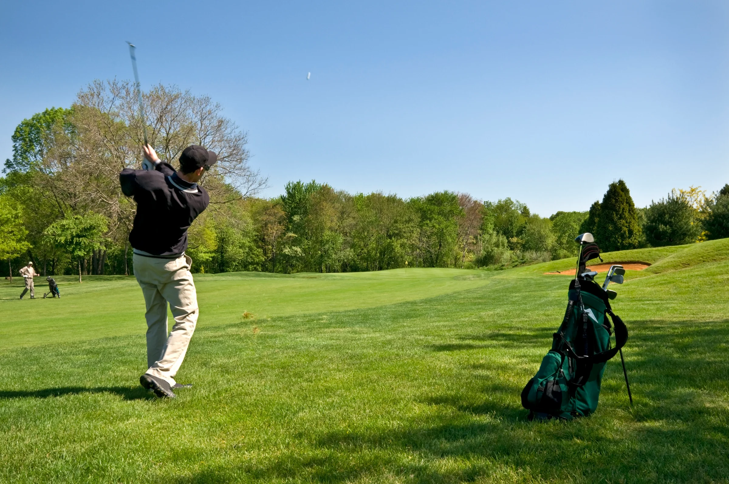 two golfers on opposite sides of the fairway