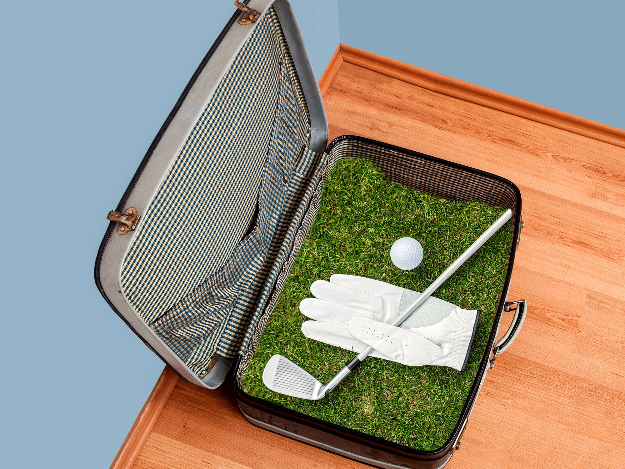Golf suitcase packed with club, ball and glove