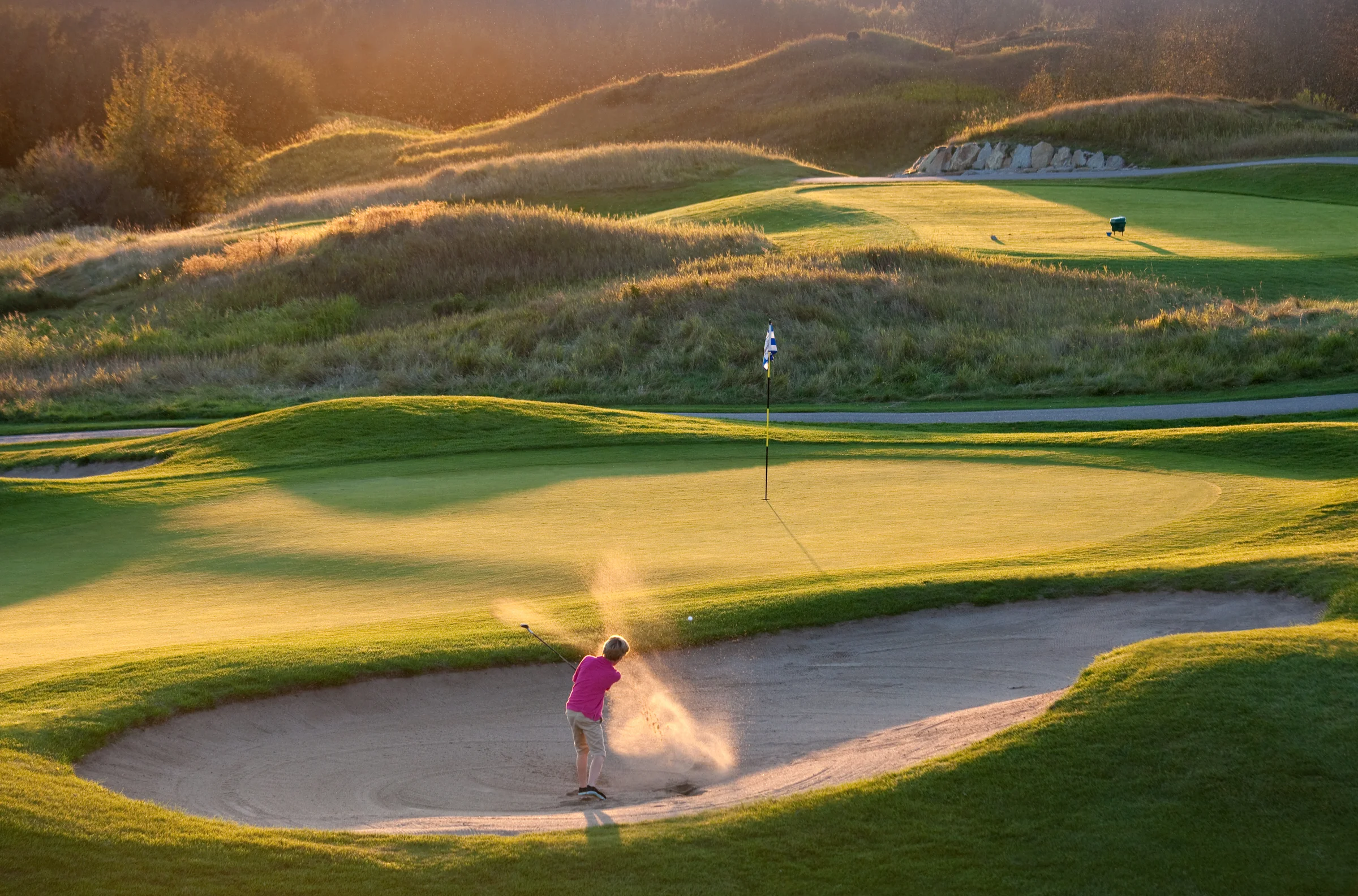 Golfer hits a greenside bunker shot