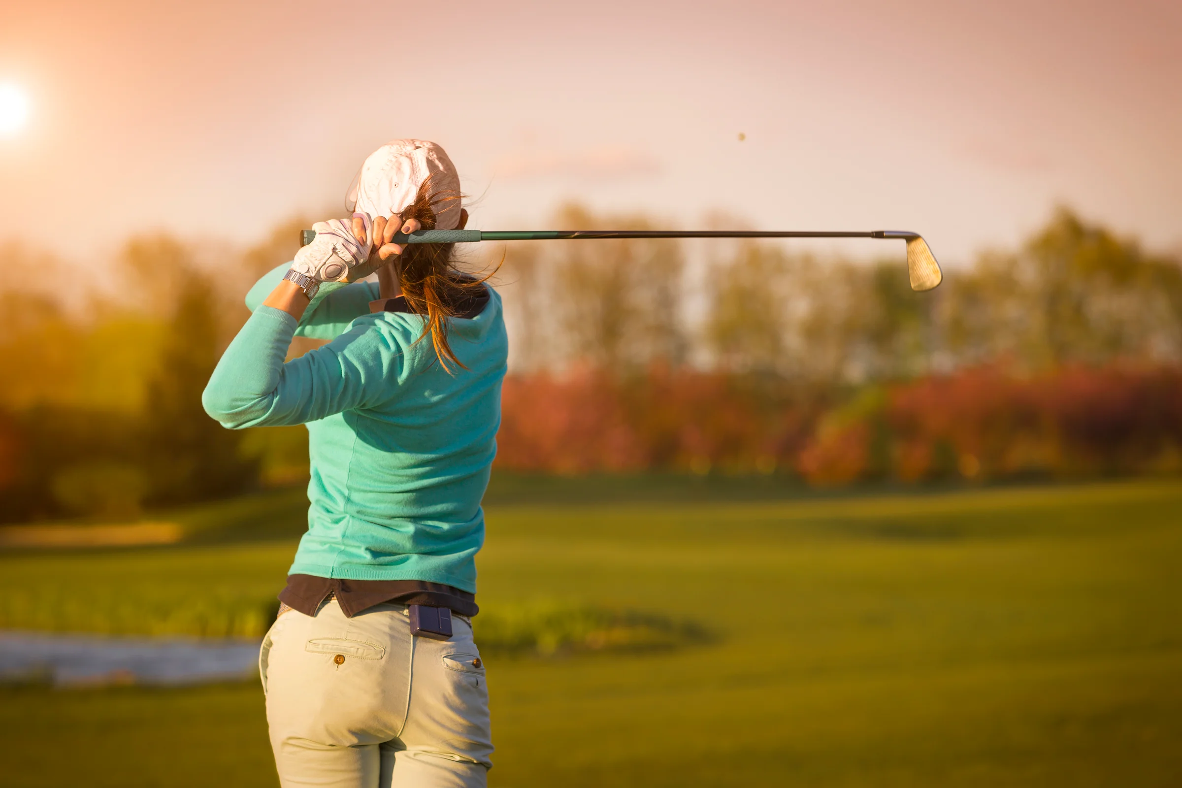 Woman golfer hitting an iron shot