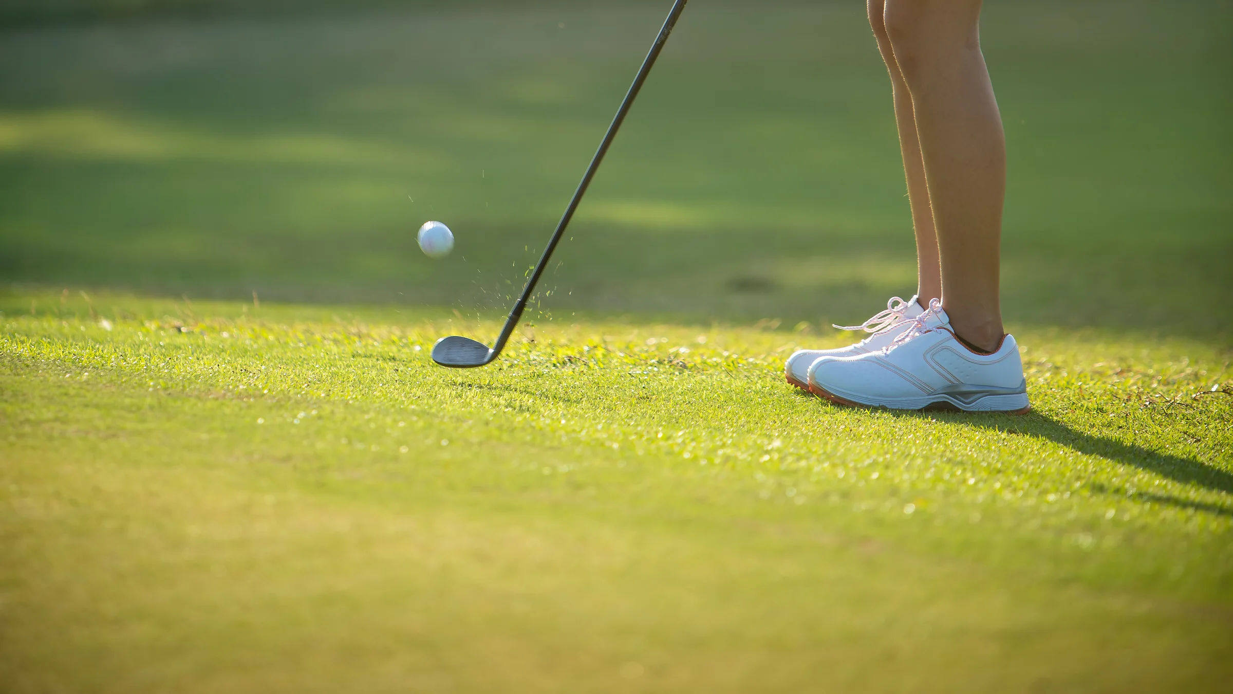 Golfer hitting a 2-hop and stop chip shot