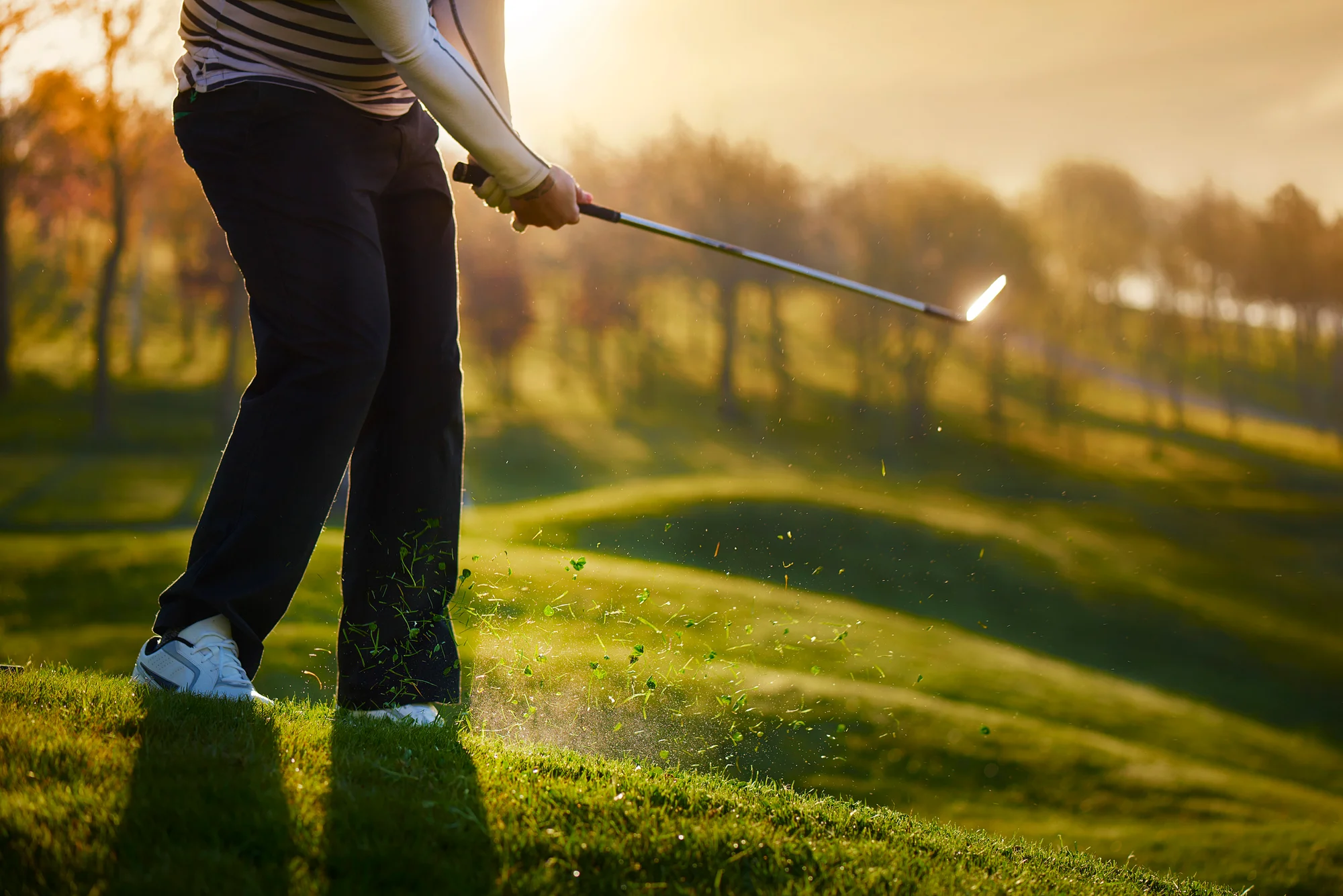 Golfer hitting a chip from thick rough