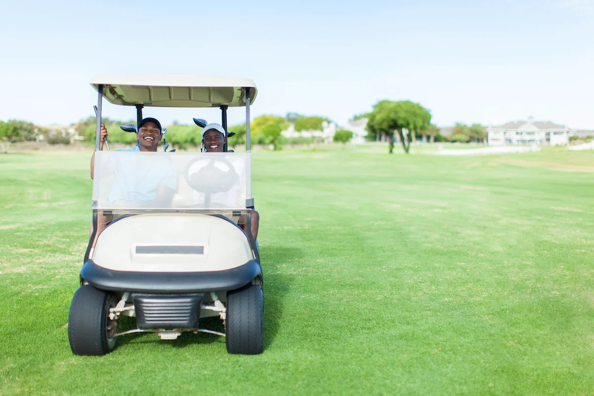 Two golfers driving golf cart